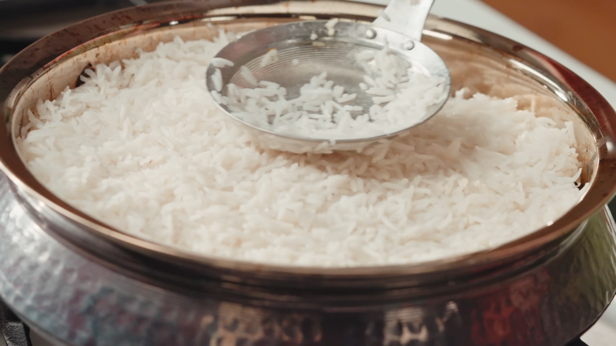 Rice ladled in a metal pot.