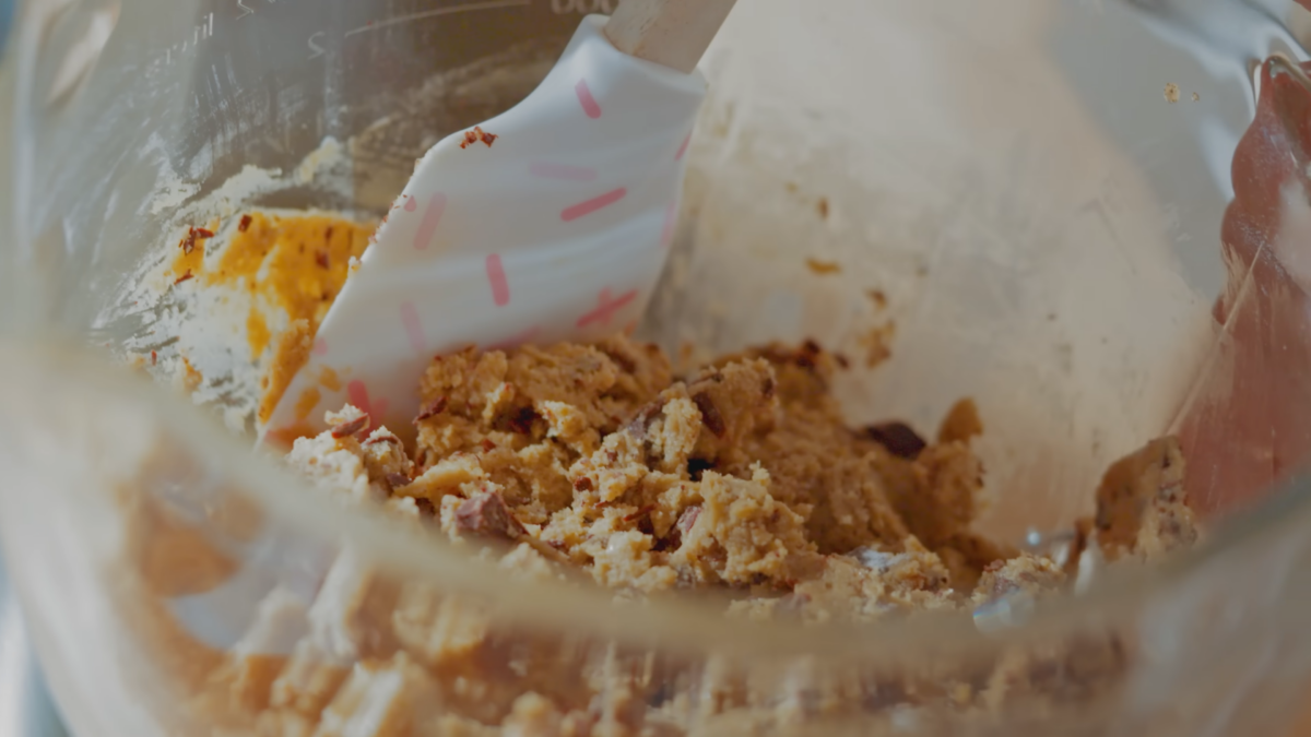 Chocolate chip cookie dough in a glass mixing bowl.