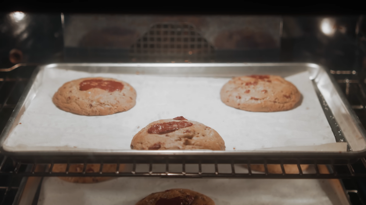 Chocolate chip cookies baking in an oven.