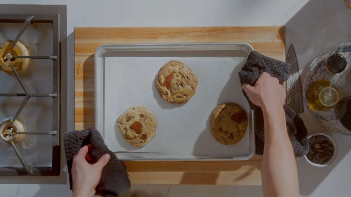 Chocolate chip cookies on parchment paper on a baking sheet.