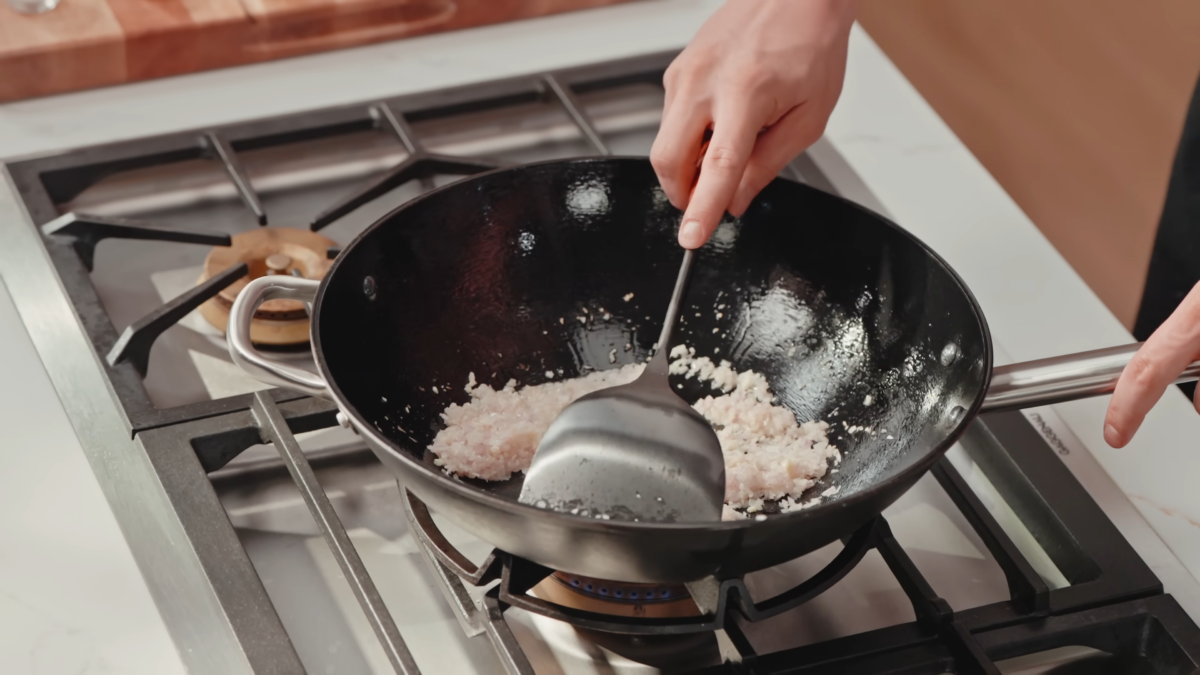 Sautéed minced onions and garlic in a wok.