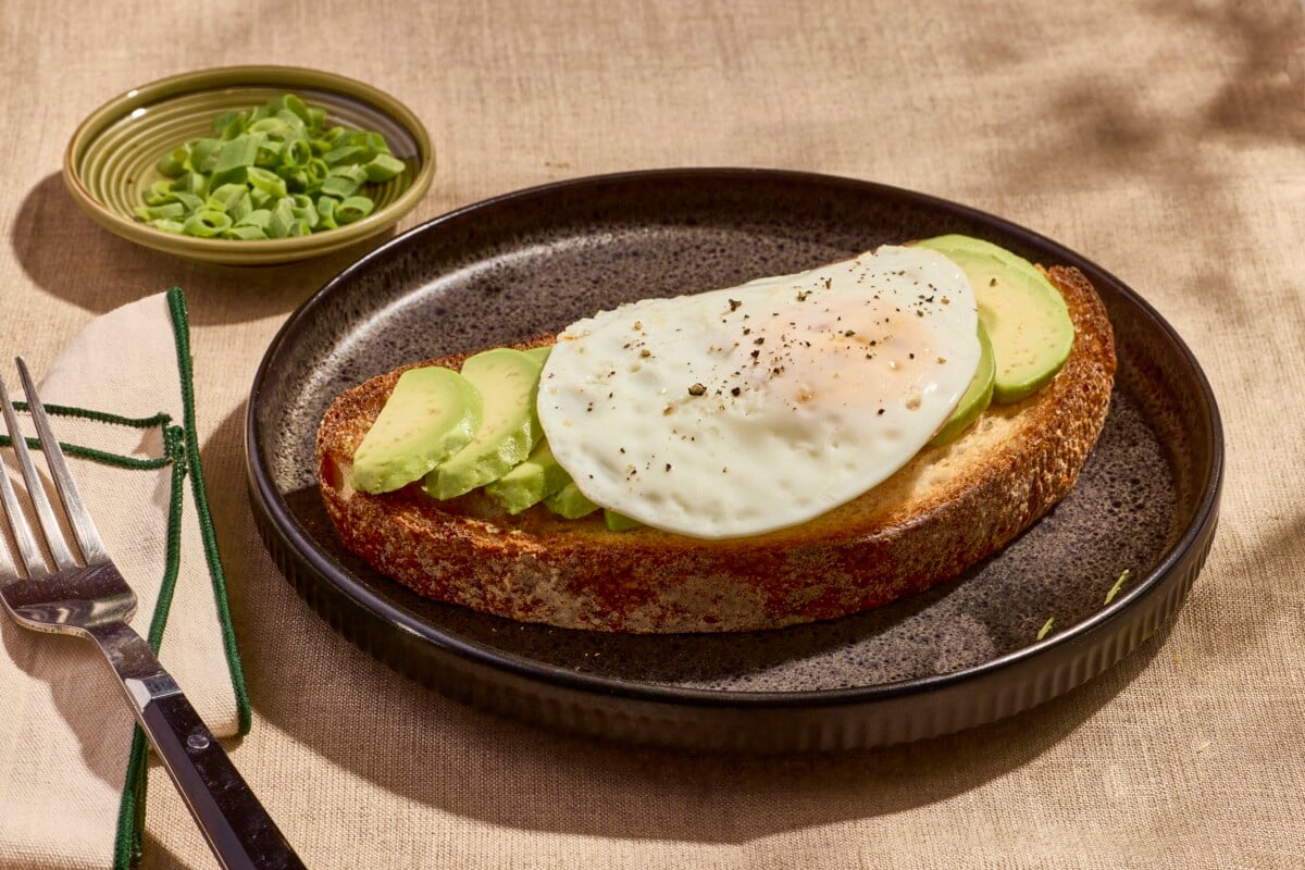 An over easy on a slice of avocado toast.