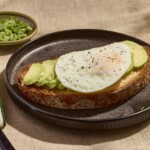 An over easy on a slice of avocado toast.