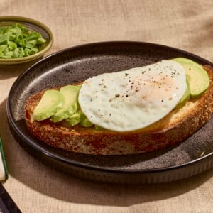 An over easy on a slice of avocado toast.