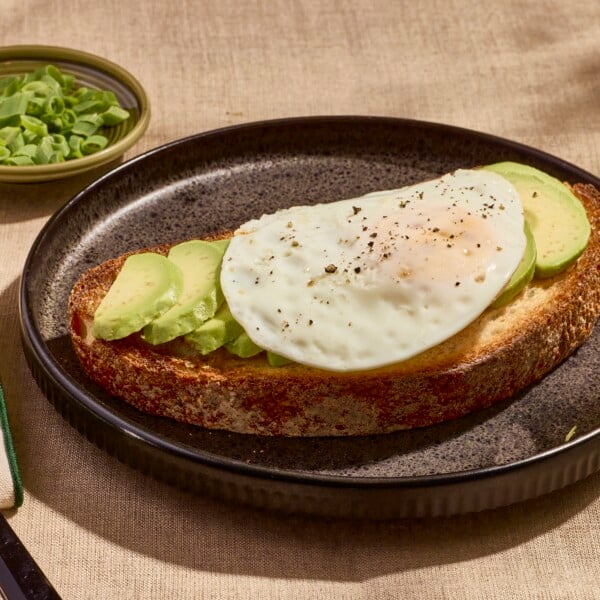An over easy on a slice of avocado toast.