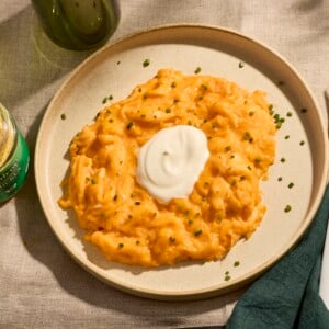 A plate of soft scrambled eggs topped with crème fraiche and chives.
