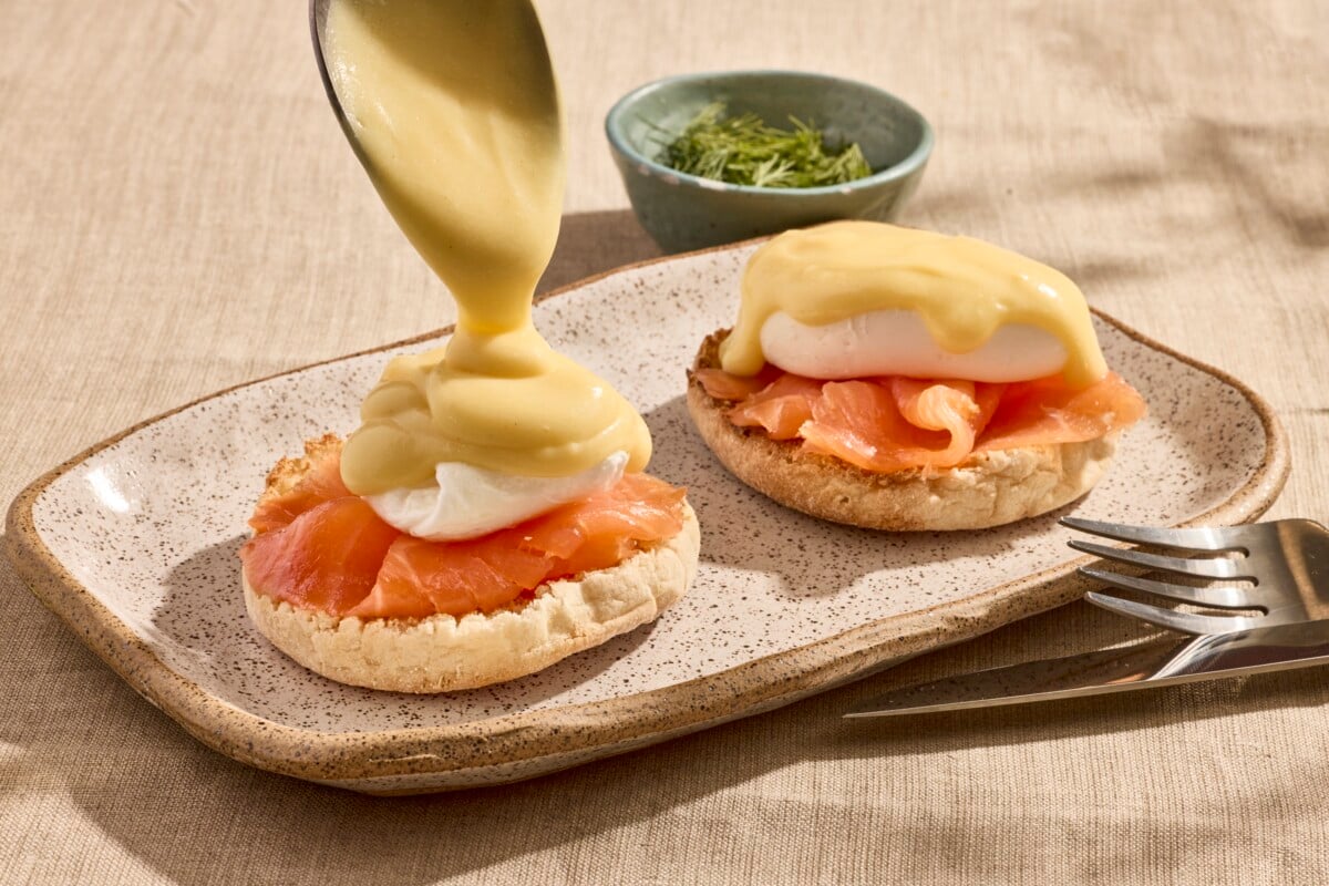 Two biscuits topped with smoked salmon, poached eggs, and hollandaise sauce. 