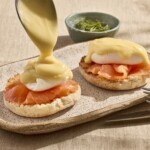 Two biscuits topped with smoked salmon, poached eggs, and hollandaise sauce.