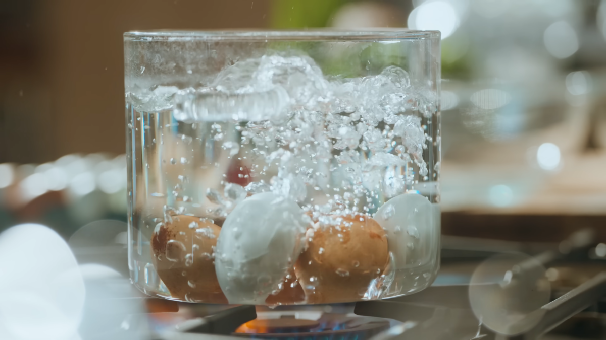 Eggs boiling in a glass pot.