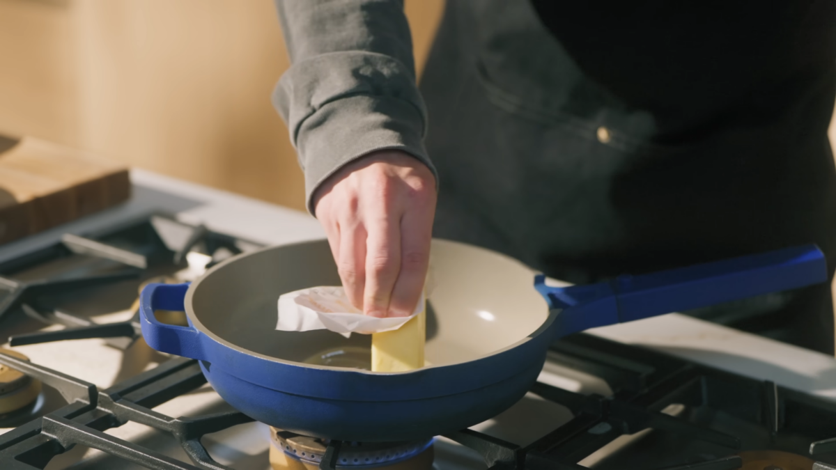 A man melting butter in a pan.
