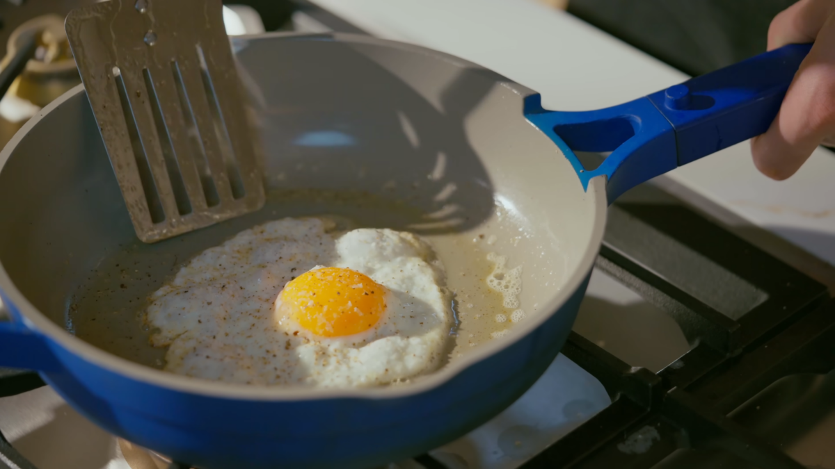An over medium egg cooking in a frying pan.