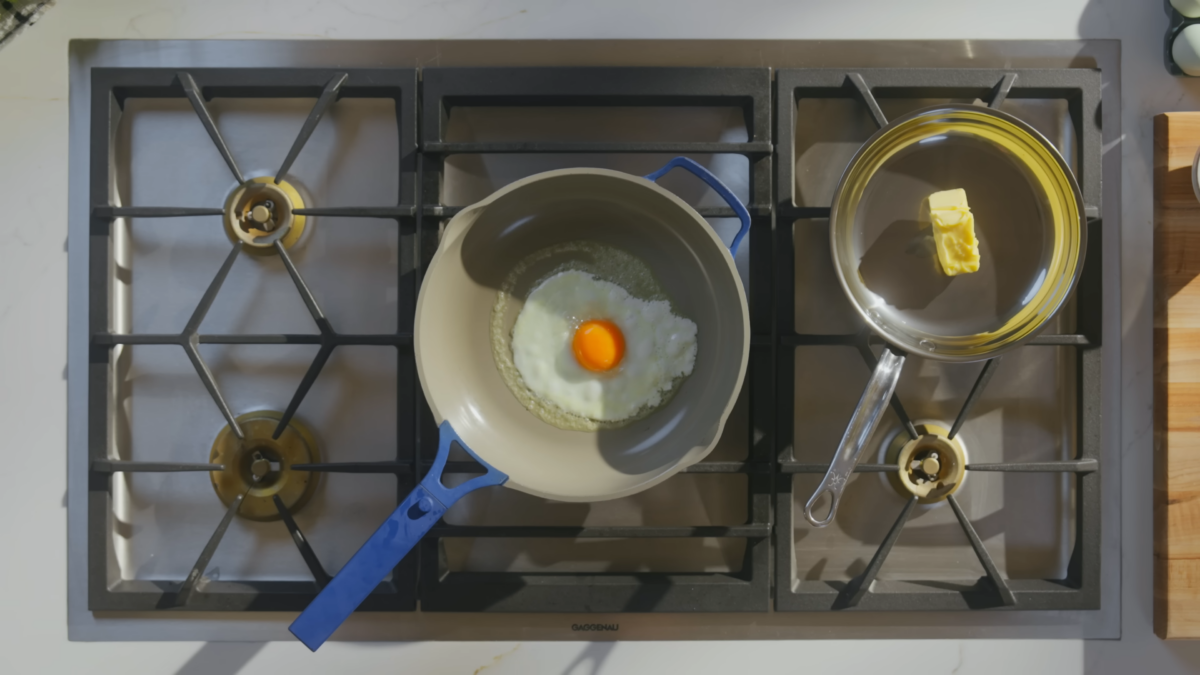 An egg cooking in a skillet on a stove.