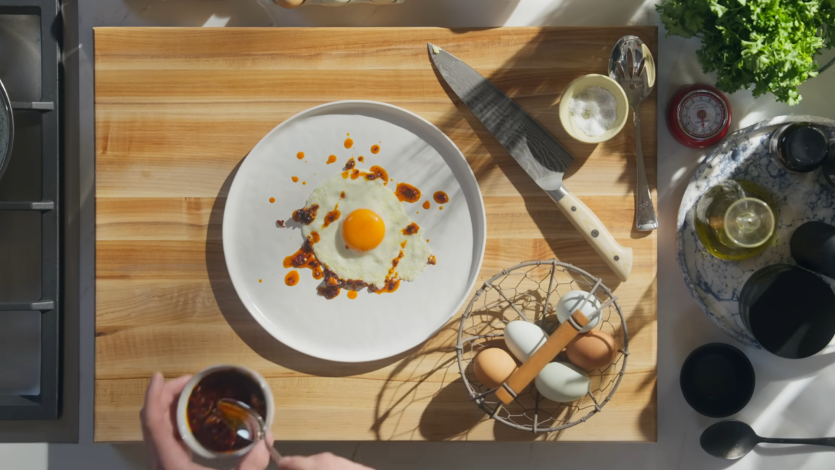 A sunny side up egg on a plate with chili crisp.
