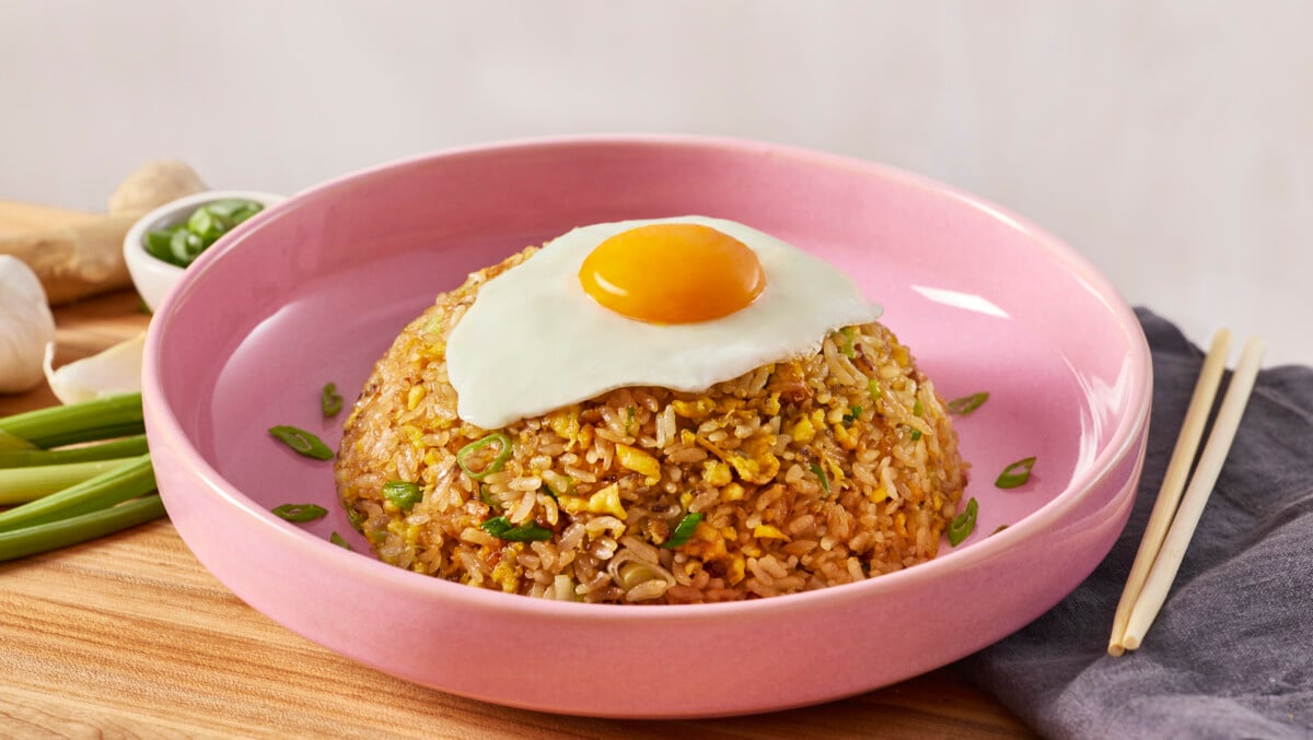 A bowl of egg fried rice topped with a fried egg.