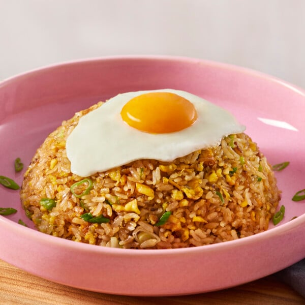 A bowl of egg fried rice topped with a fried egg.