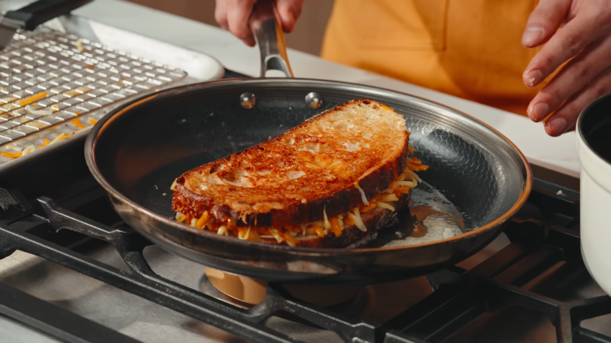 A grilled cheese sandwich cooking in a pan.