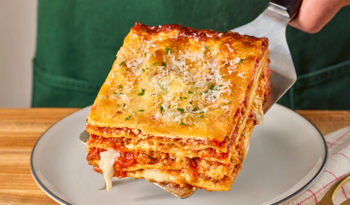 A spatula holding a serving of lasagna.