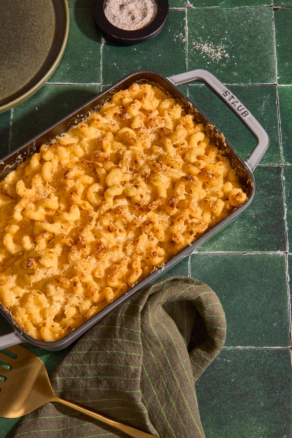 A baking dish full of five cheese mac and cheese on a green counter.