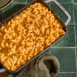 A baking dish full of five cheese mac and cheese on a green counter.