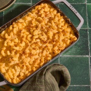 A baking dish full of five cheese mac and cheese on a green counter.