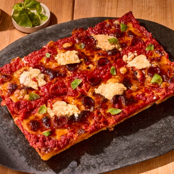 A sheet pan pizza topped with ricotta and fresh basil.