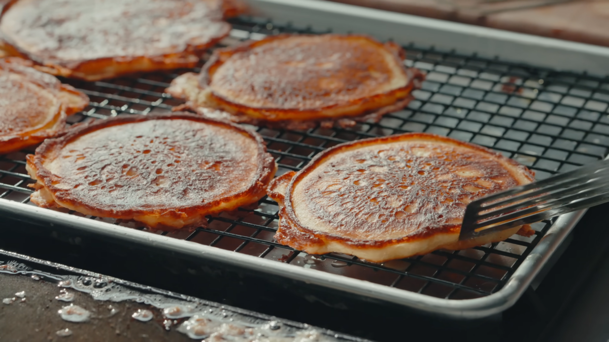 Pancakes resting on a wire rack.