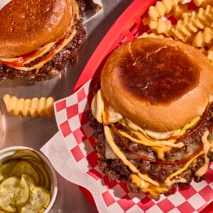 A smashburger in a basket with fries.