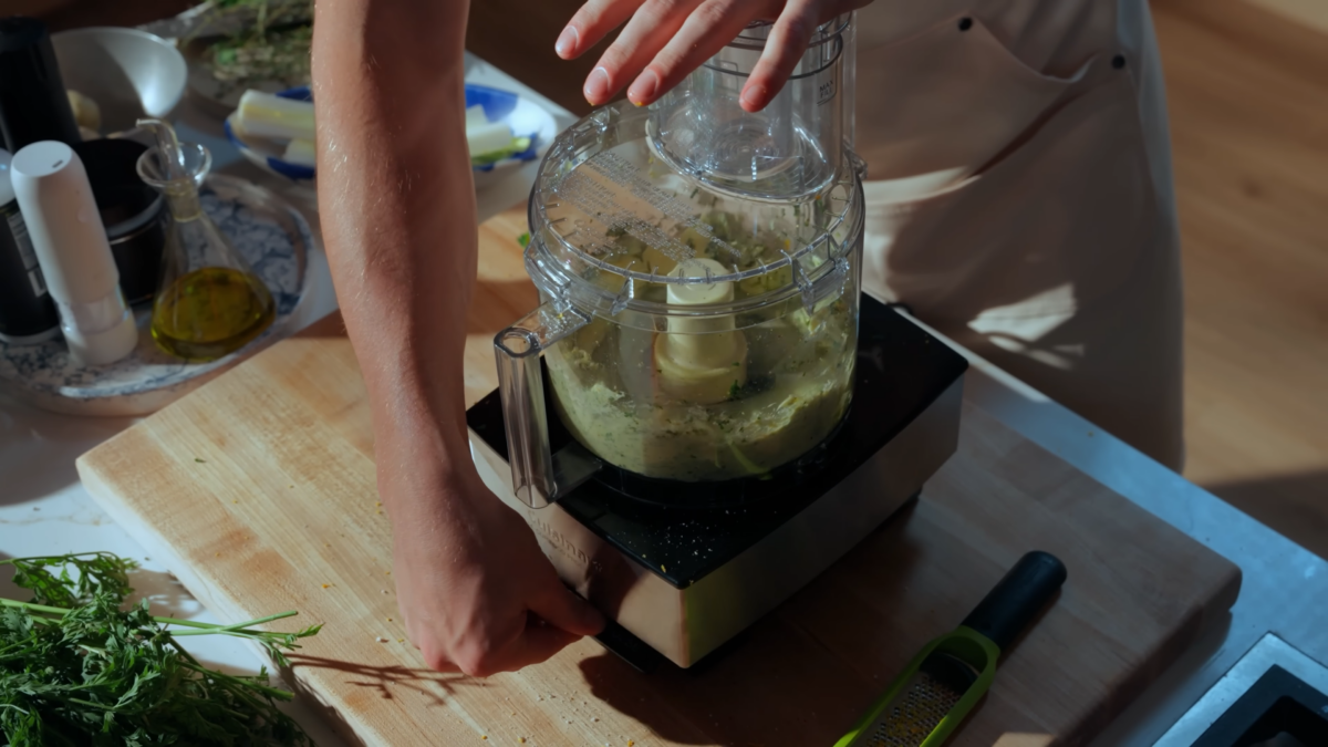 Butter and herbs blending in a food processor.