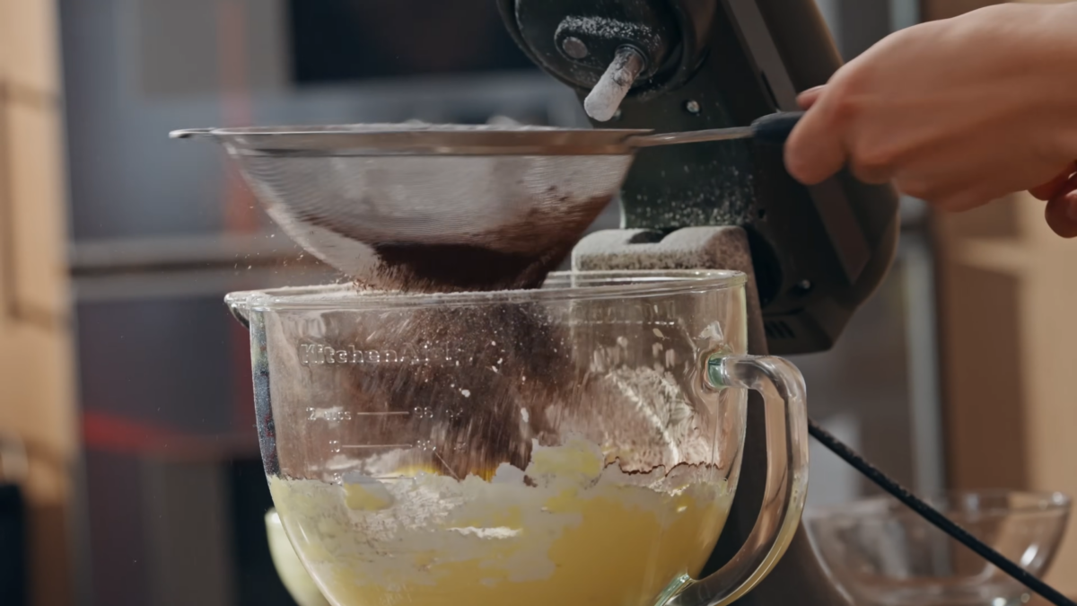 Butter being mixed in a glass bowl.