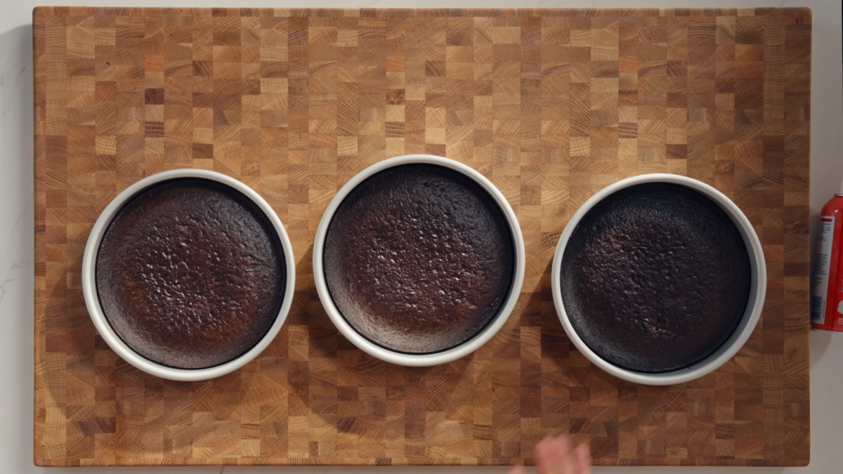 Cake tins with baked chocolate cake layers.