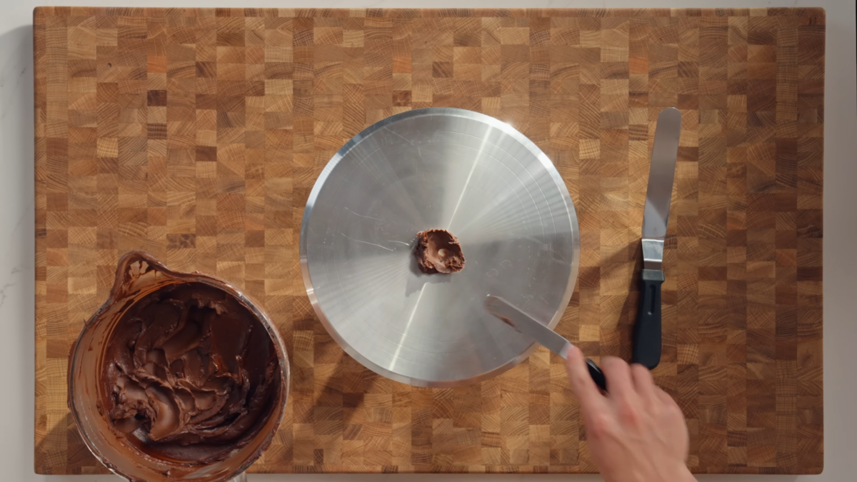 A dollop of chocolate frosting on a cake stand.