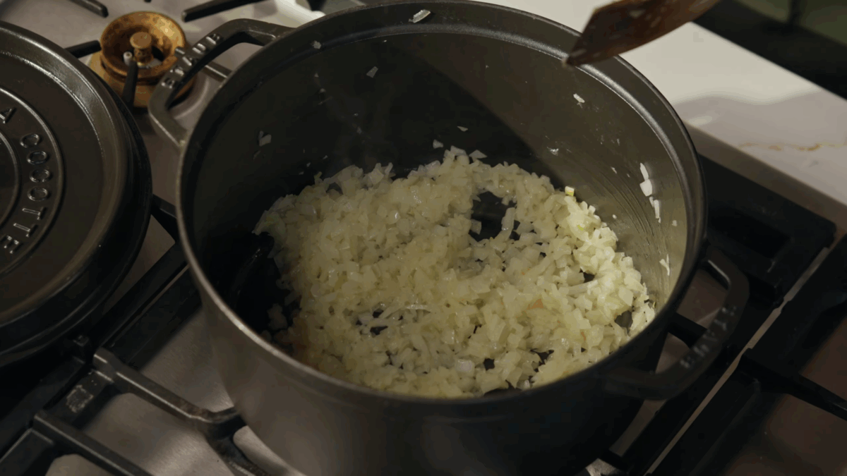 Onions and garlic sautéing in a Dutch oven.