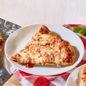 A slice of New York style pizza on a white plate.