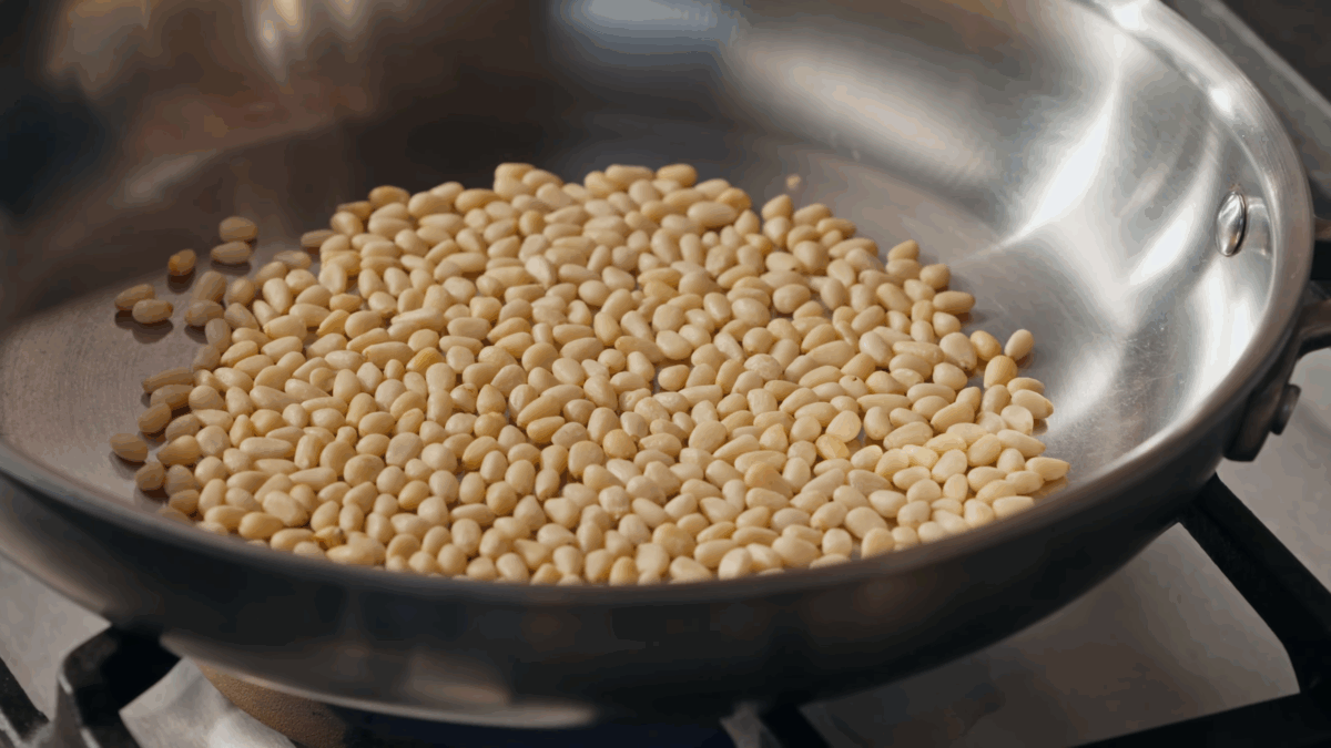 Pine nuts toasting in a skillet. 