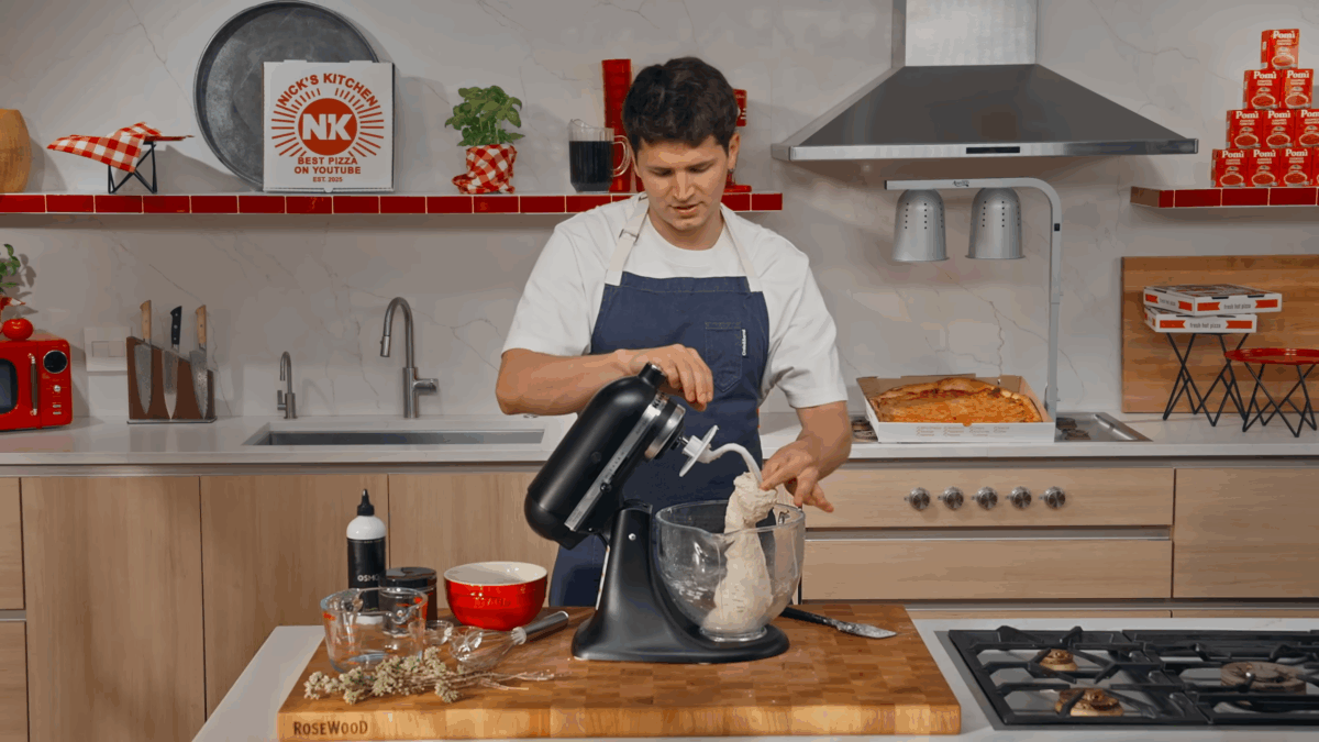 Pizza dough being kneaded in a stand mixer. 