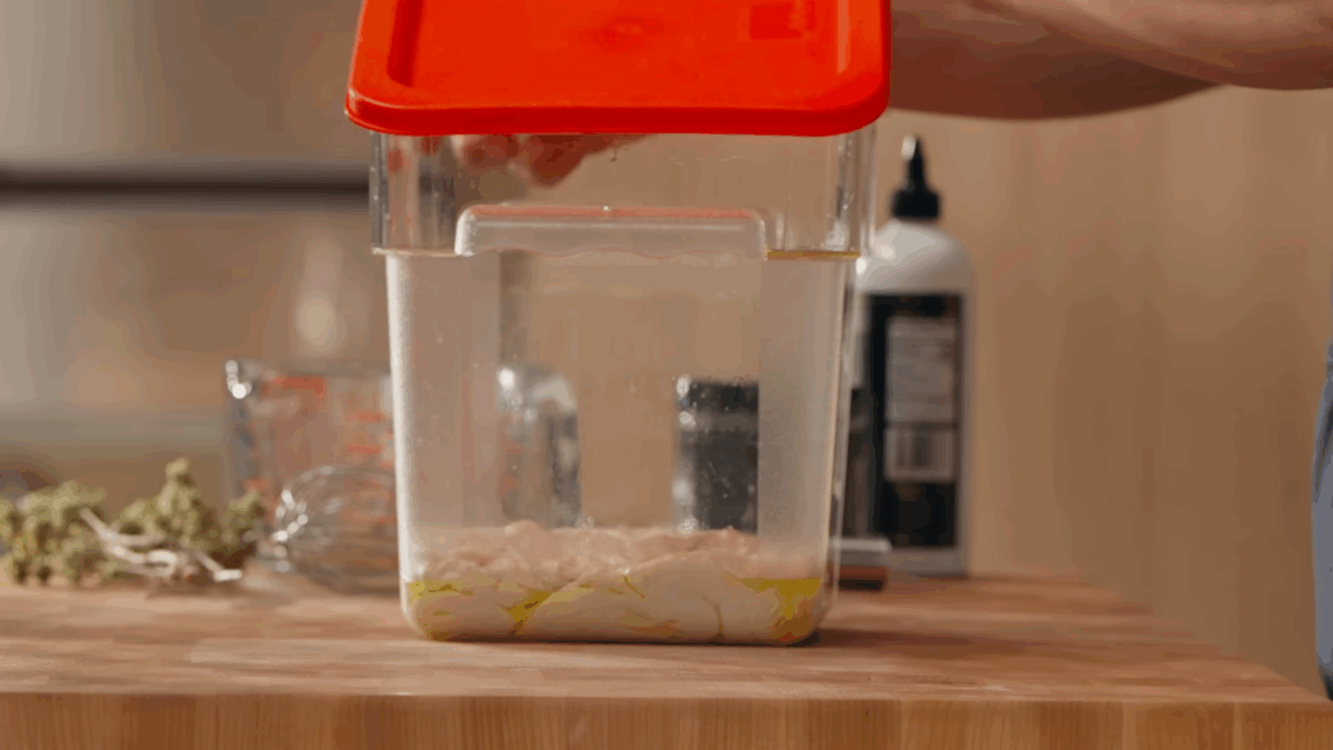 Fermented pizza dough in a plastic container. 