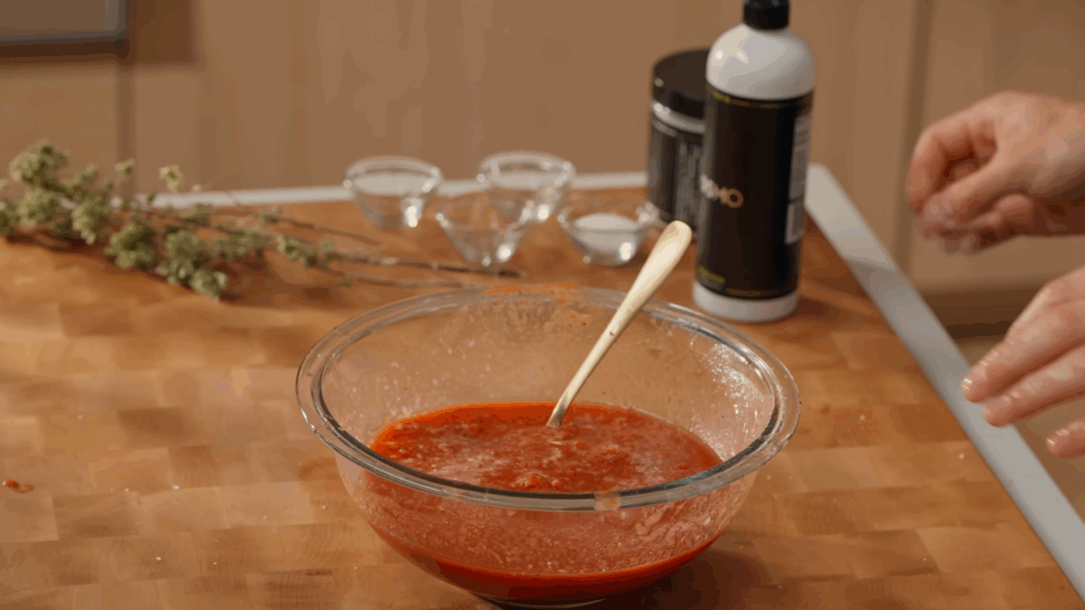 A bowl of tomato sauce with a spoon sticking out. 