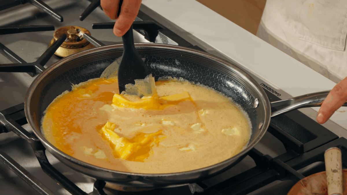 Eggs being scrambled in a skillet. 