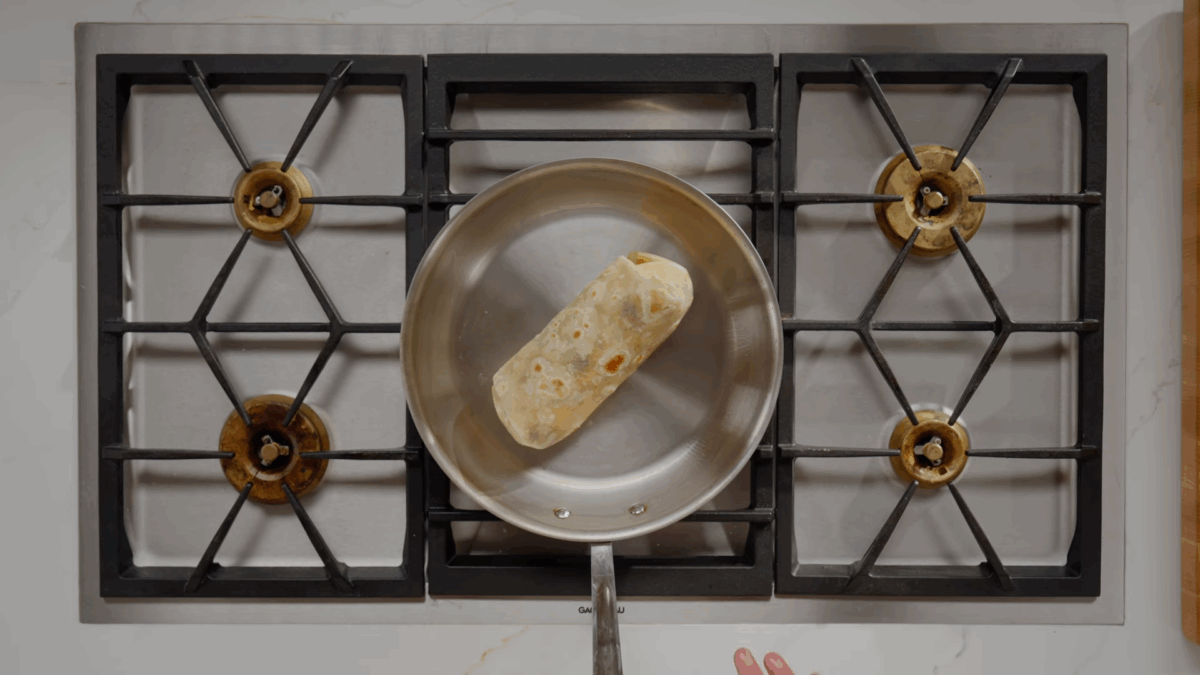 A homemade breakfast burrito cooking in a skillet. 
