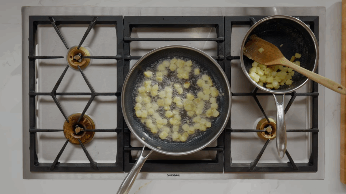 Boiled potatoes being fried in oil. 