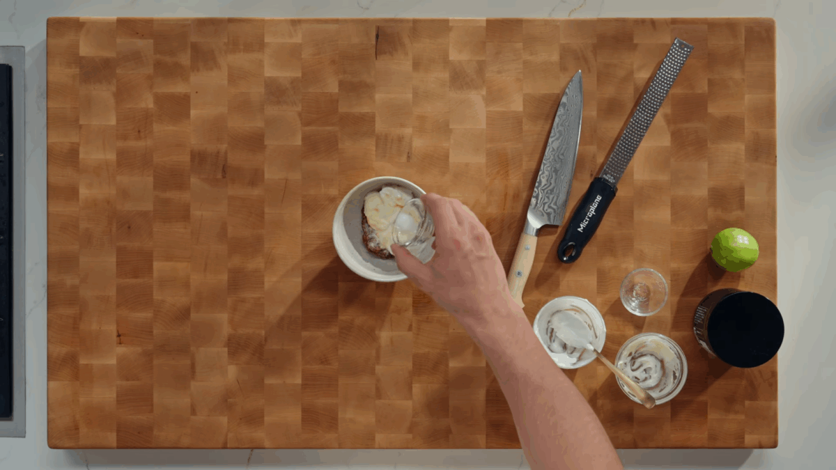 Chipotle sauce ingredients being added to a white bowl. 