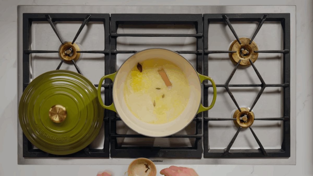 A pot of melted butter, cinnamon, cardamom pods, and cloves.