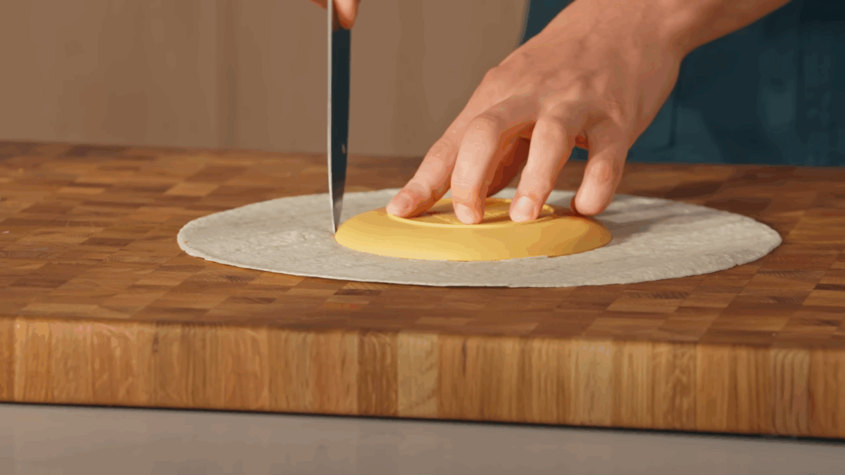 A tortilla shell being trimmed. 