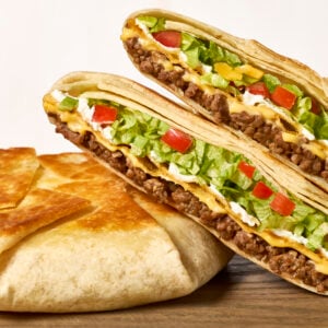 Two homemade crunchwrap supremes, one split in half.