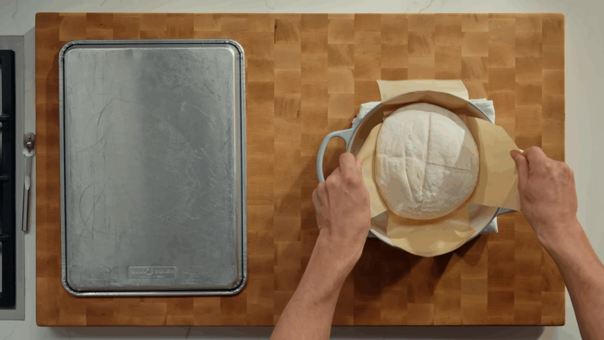 Nick DiGiovanni transferring a sourdough bread dough loaf to a Dutch oven.