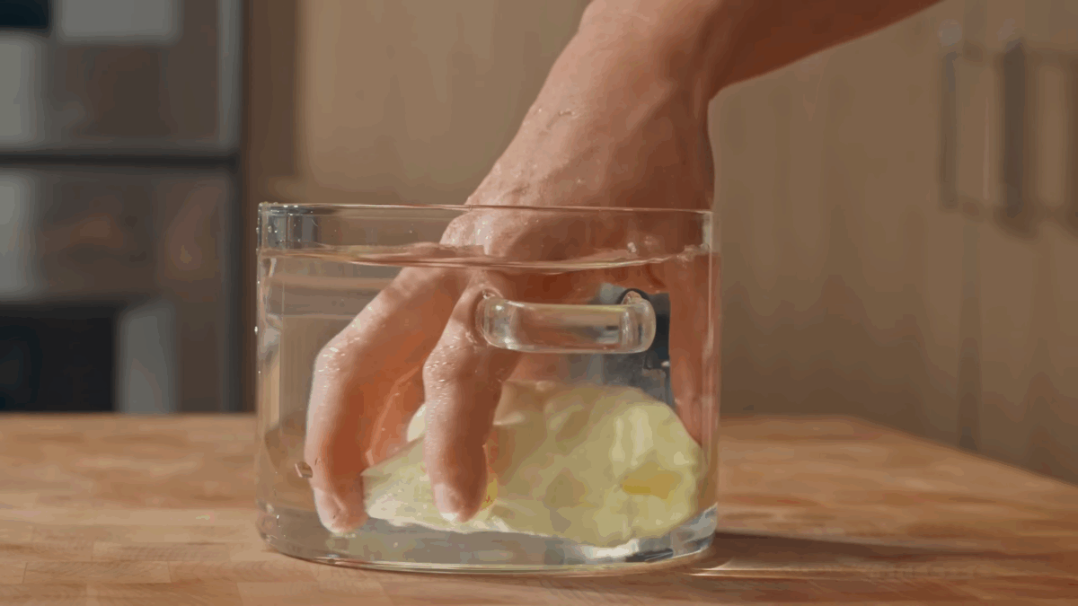 Nick DiGiovanni rinsing homemade butter in a jar of cold water.