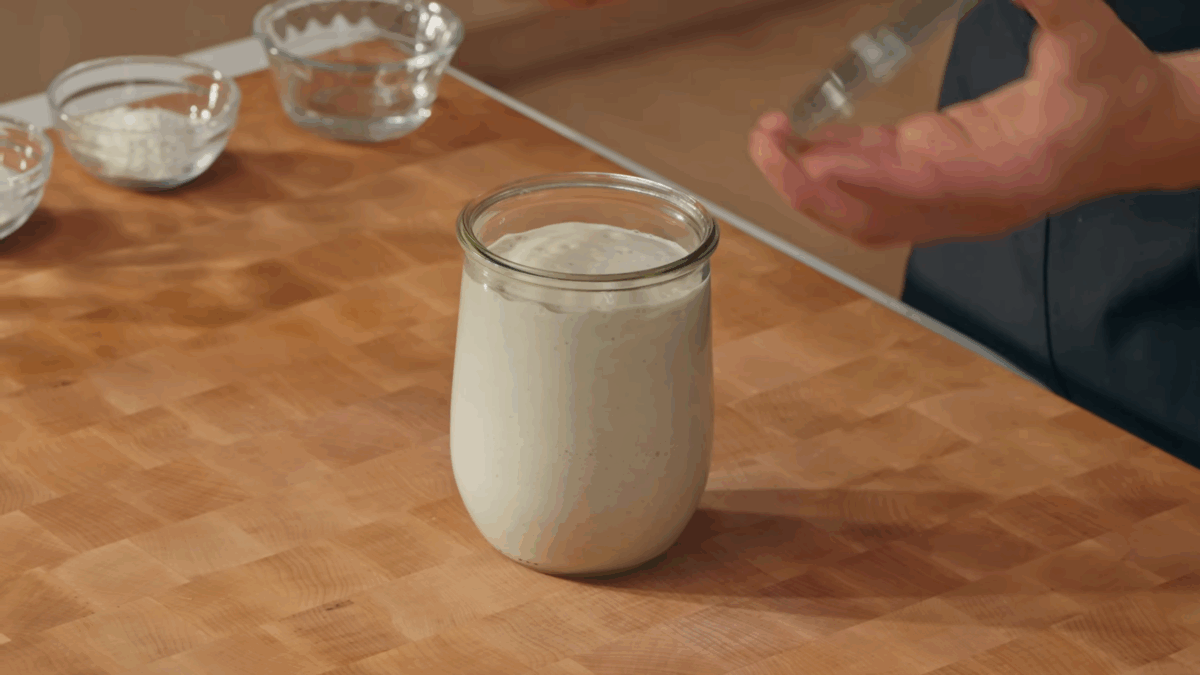 A glass jar of active sourdough starter.