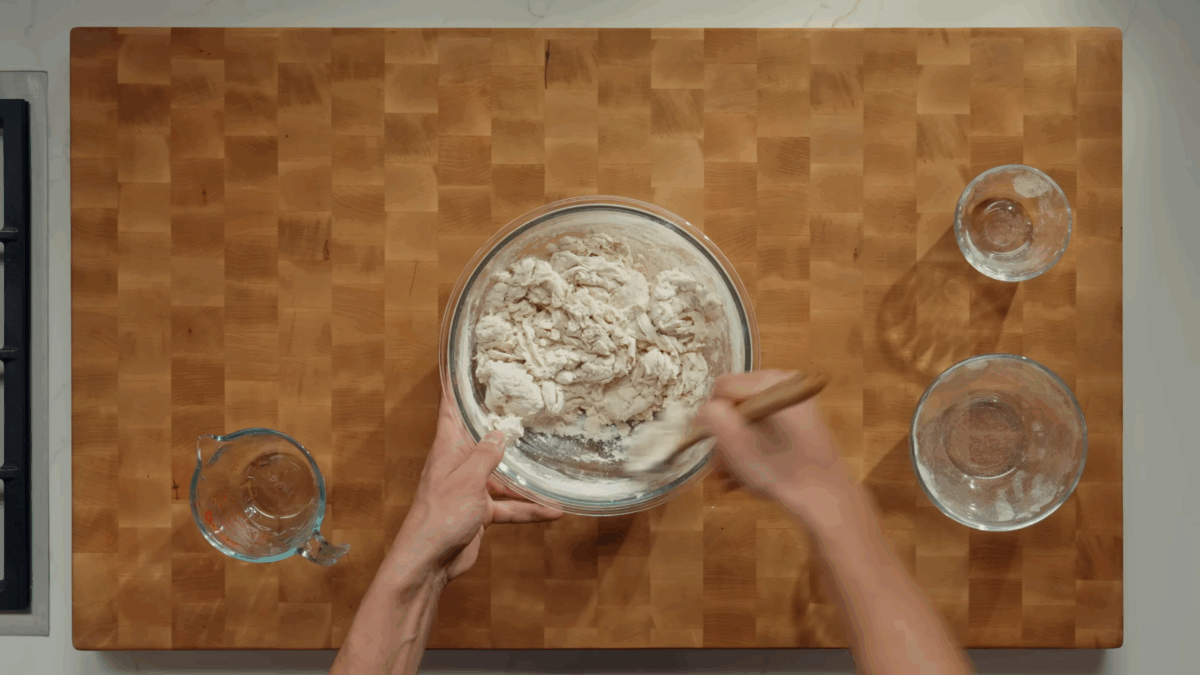 Nick DiGiovanni mixing sourdough bread ingredients in a bowl.