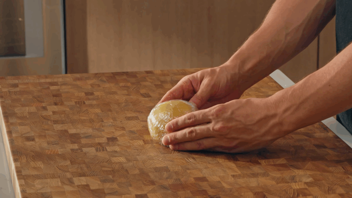 Nick DiGiovanni holding pasta dough wrapped with plastic wrap.
