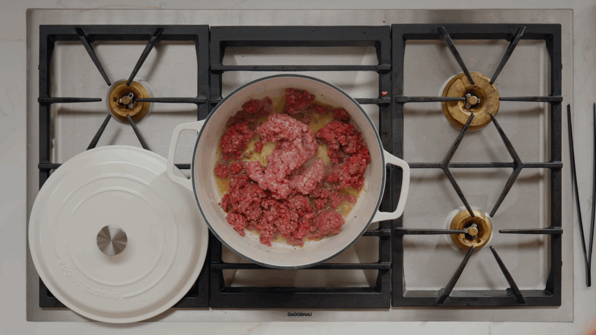 Ground beef and pork browning in a Dutch oven.